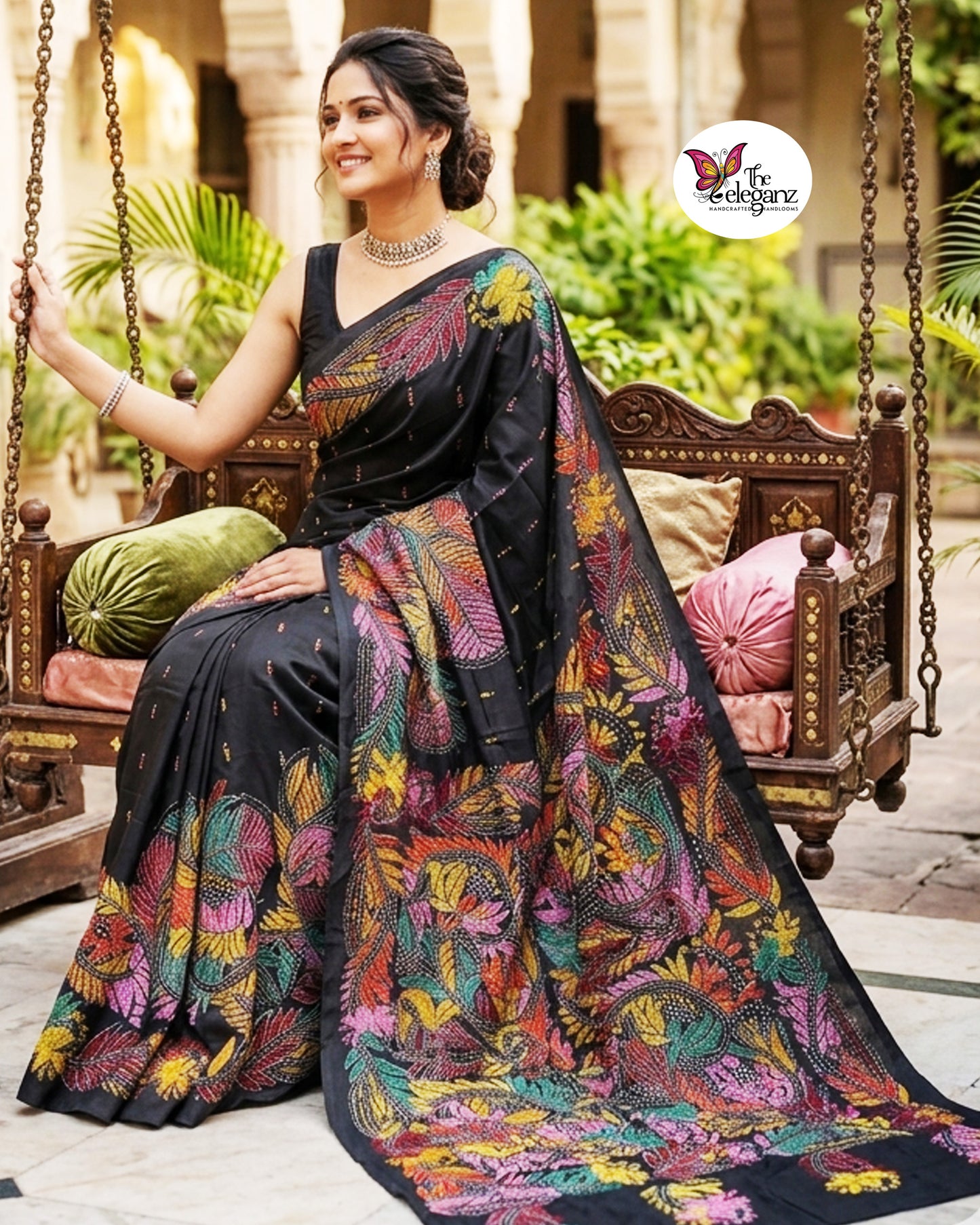 Woman draped in a black blended Bangalore silk saree featuring colourful Padma Kantha embroidery with lotus flowers, vines, and traditional Bengali motifs