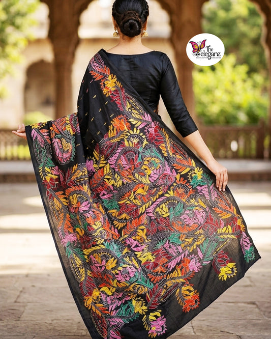 Woman draped in a black blended Bangalore silk saree featuring colourful Padma Kantha embroidery with lotus flowers, vines, and traditional Bengali motifs