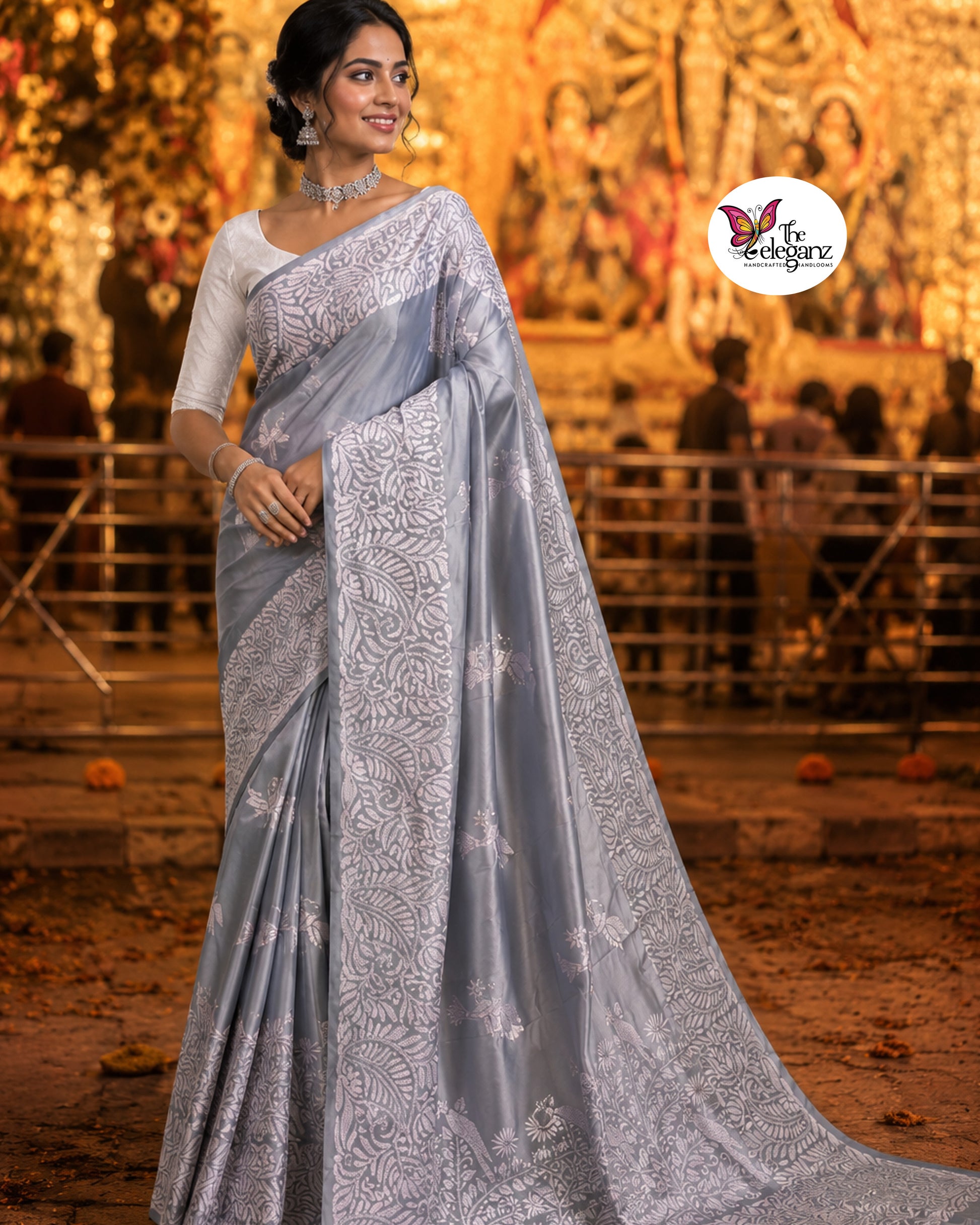 Woman draped in a steel grey blended Bangalore silk saree featuring intricate white Kantha embroidery with bird, floral, and foliage motifs across the border and pallu.