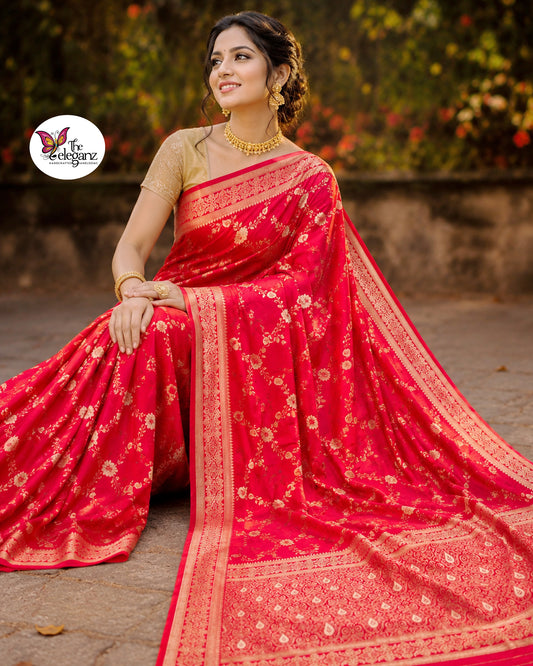 Woman draped in vermilion red Semi Mashroo Katan Silk Banarasi saree featuring floral gold zari weaving and richly woven Banarasi paisley pallu.