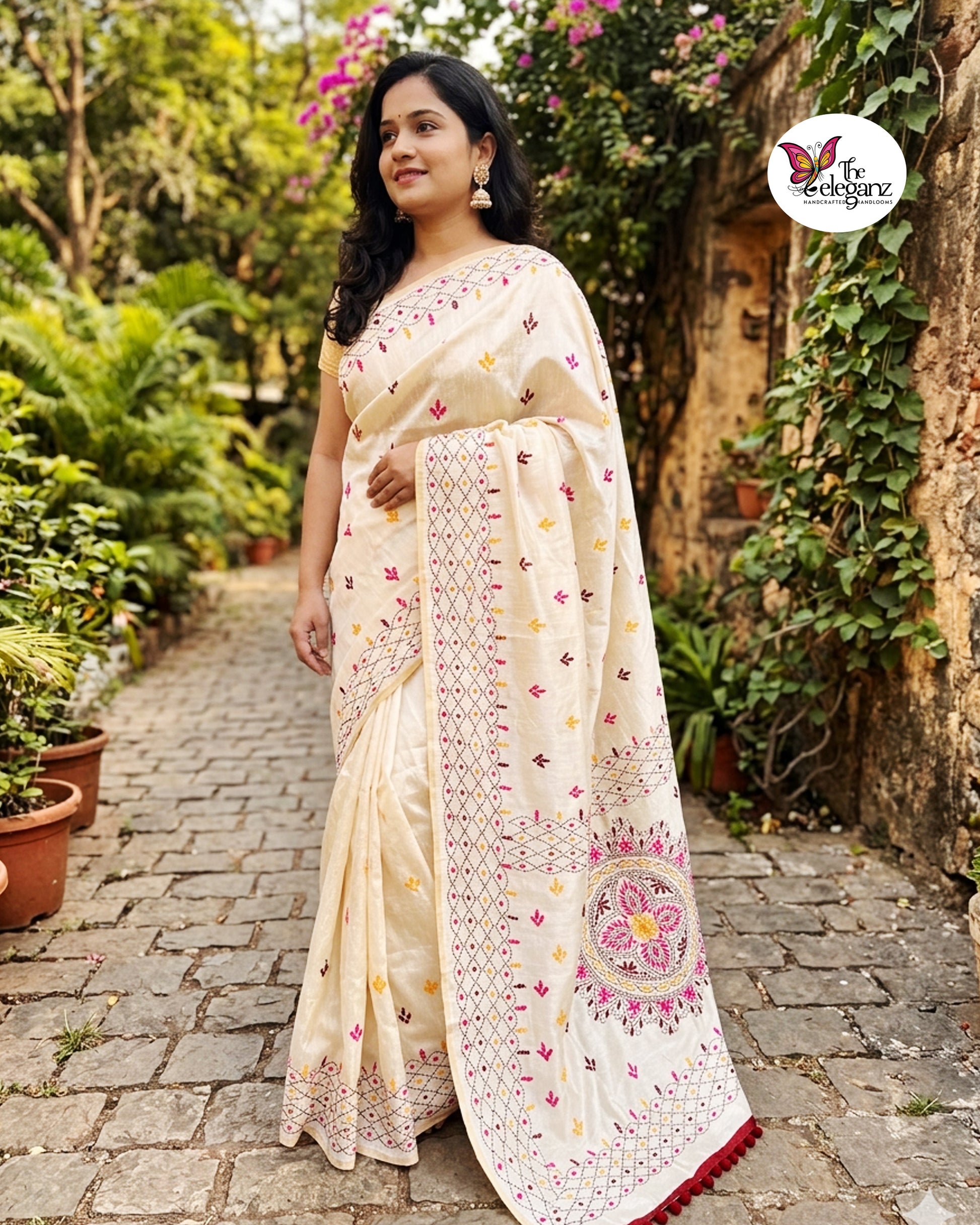 Woman draped in an ivory white embroidered semi silk saree featuring multicolour floral motifs, geometric borders, and an ornate embroidered pallu design.