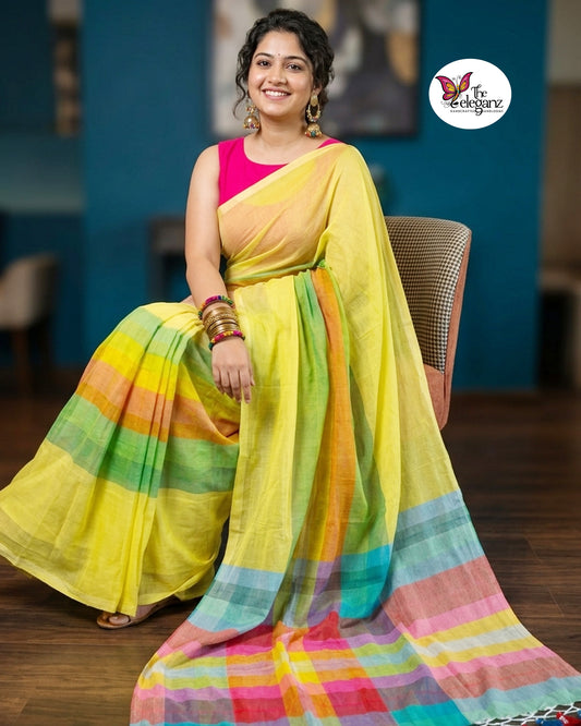 Woman wearing a lemon yellow Mul Cotton saree featuring pastel multicolour checked pallu, woven striped detailing, and handcrafted tassels.