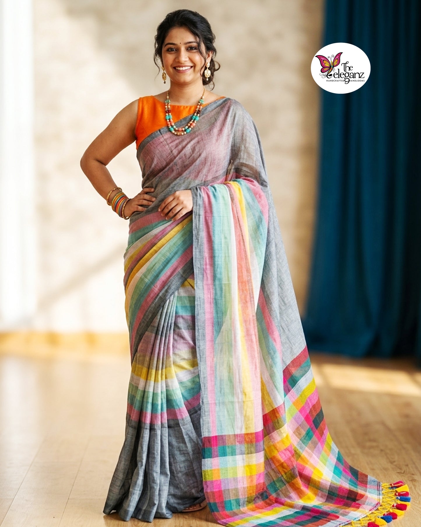 Woman draped in an ash-grey Mul Cotton saree featuring vibrant multicolour striped pallu and border with handcrafted colourful tassels.