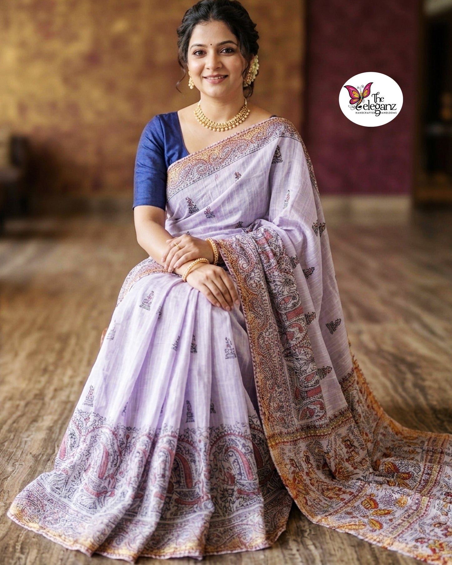 Woman draped in lavender Cotton Silk Madhubani saree featuring traditional folk art figures, paisley motifs, and intricate heritage-inspired decorative borders.